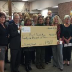 Grantees pose with giant check