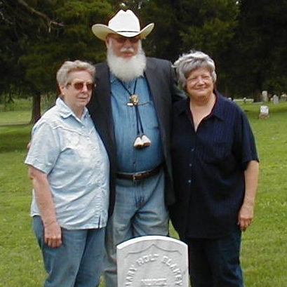 Sandra Haimerl, Arnold Schofield, and Carolyn Cooper stand behind the gravestone of a Civil War soldier that they had spent many hours researching.