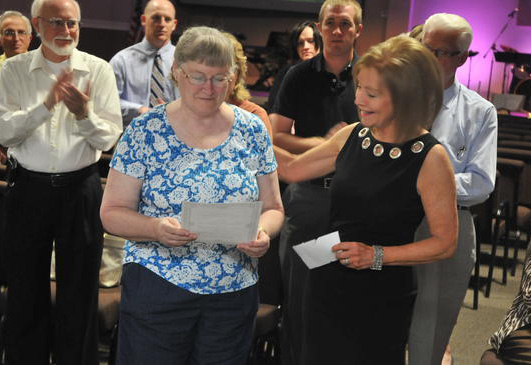 FSACF Board member handing Doloris Sonntag of Lee's Paws and Claws a check for $600.